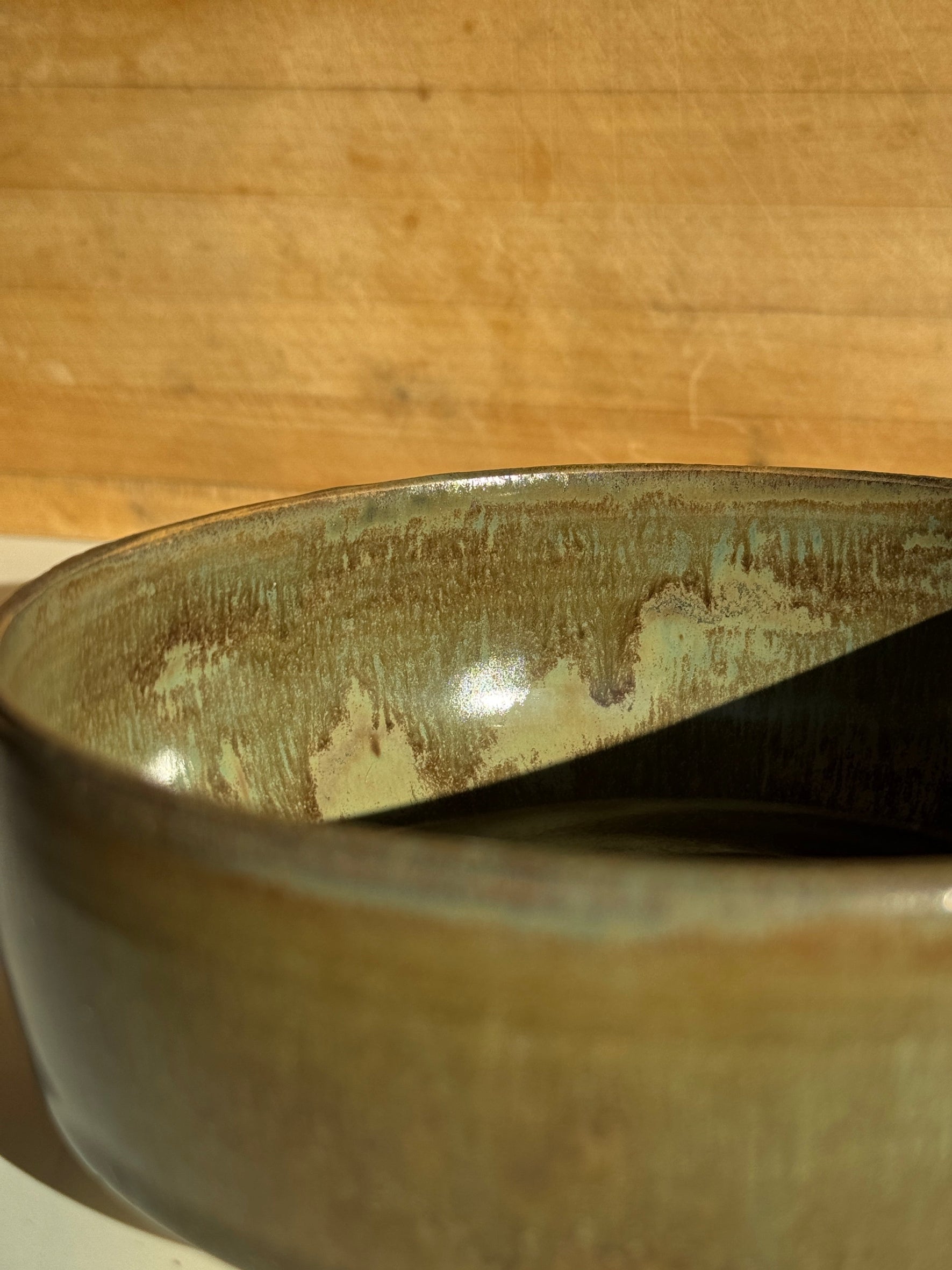 Close-up of a ceramic bowl with an olive glaze