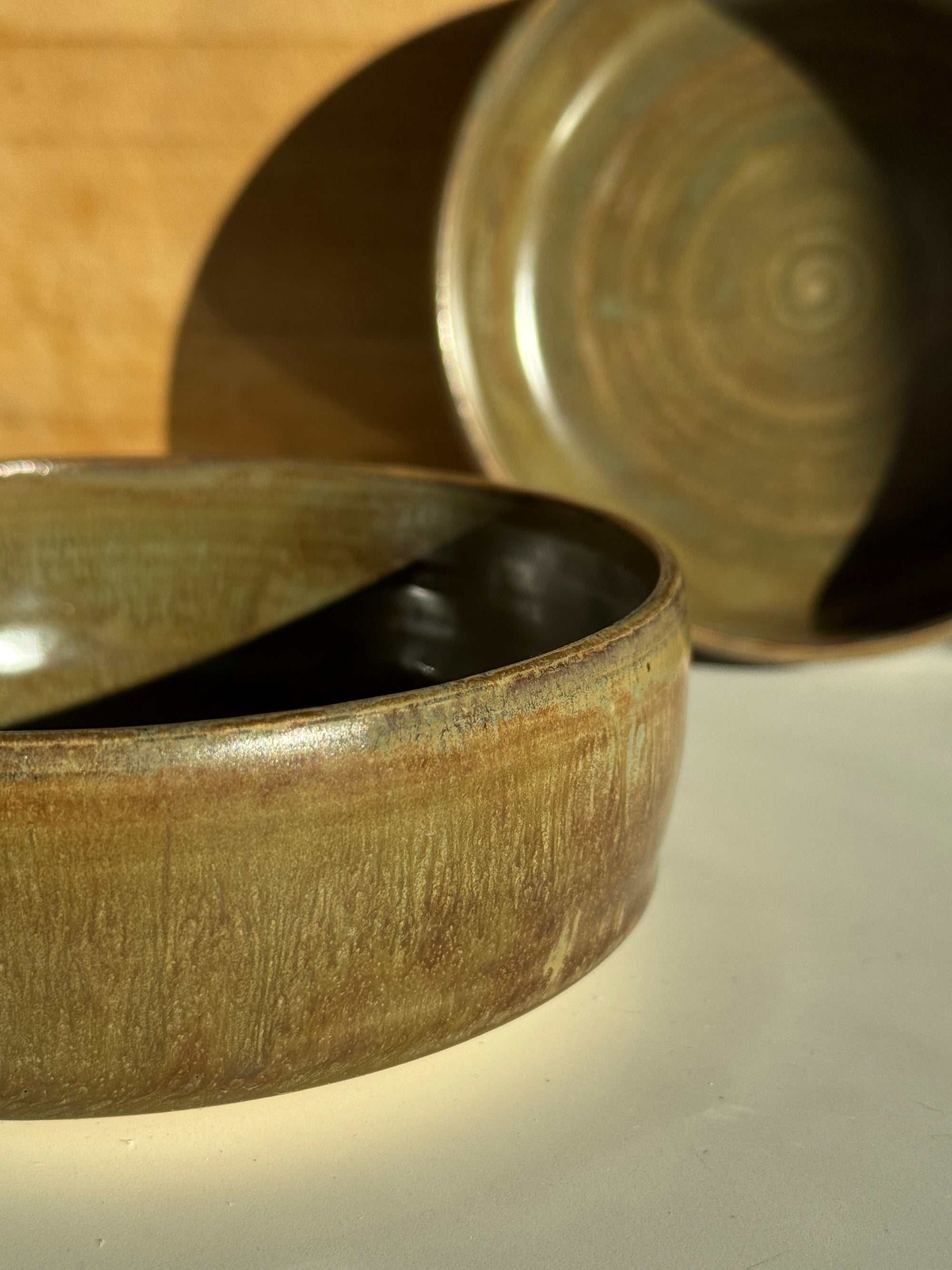 Close-up of a ceramic bowl with an olive glaze.