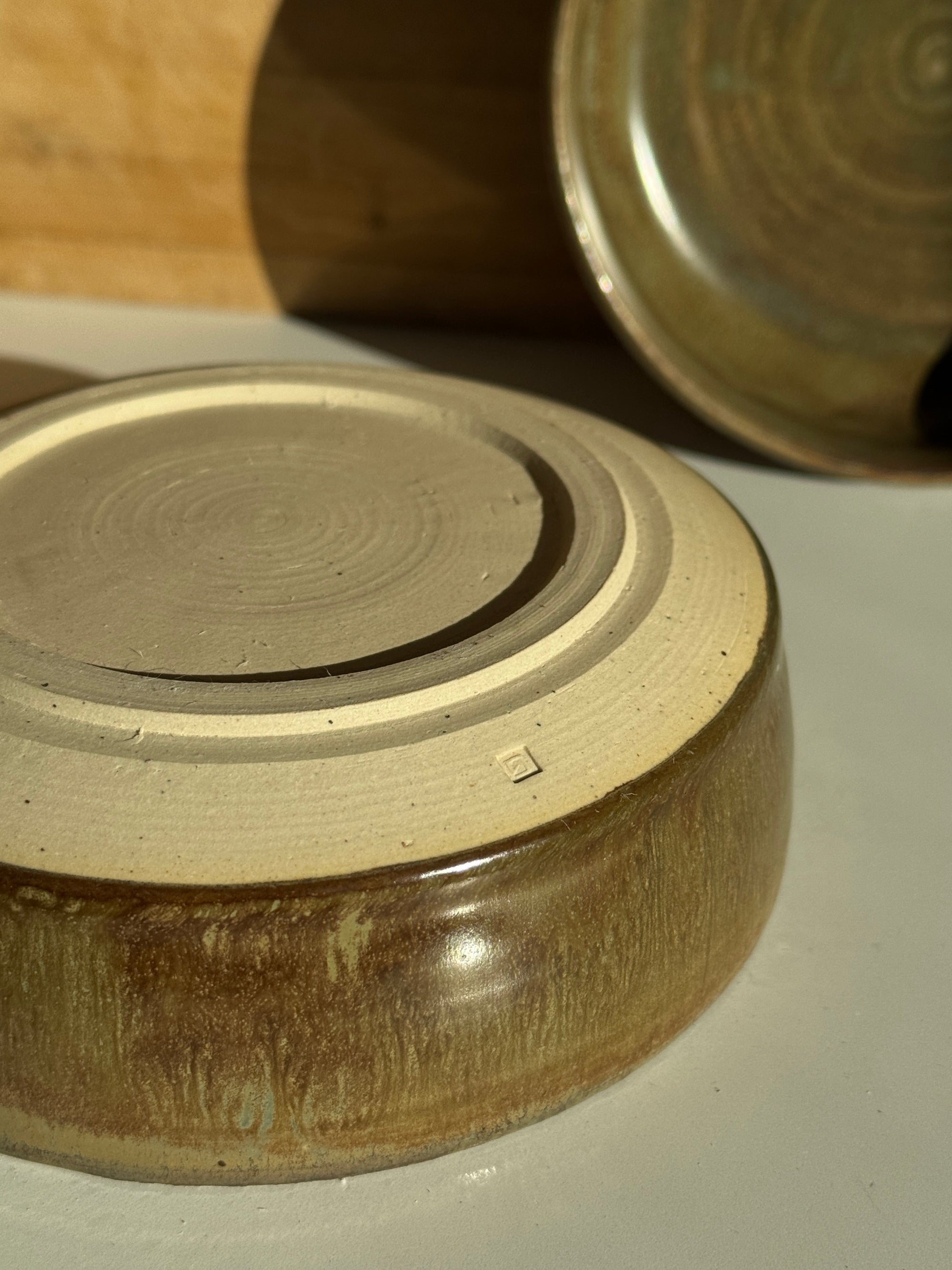 Close-up of a ceramic bowl with an olive glaze bottom footring