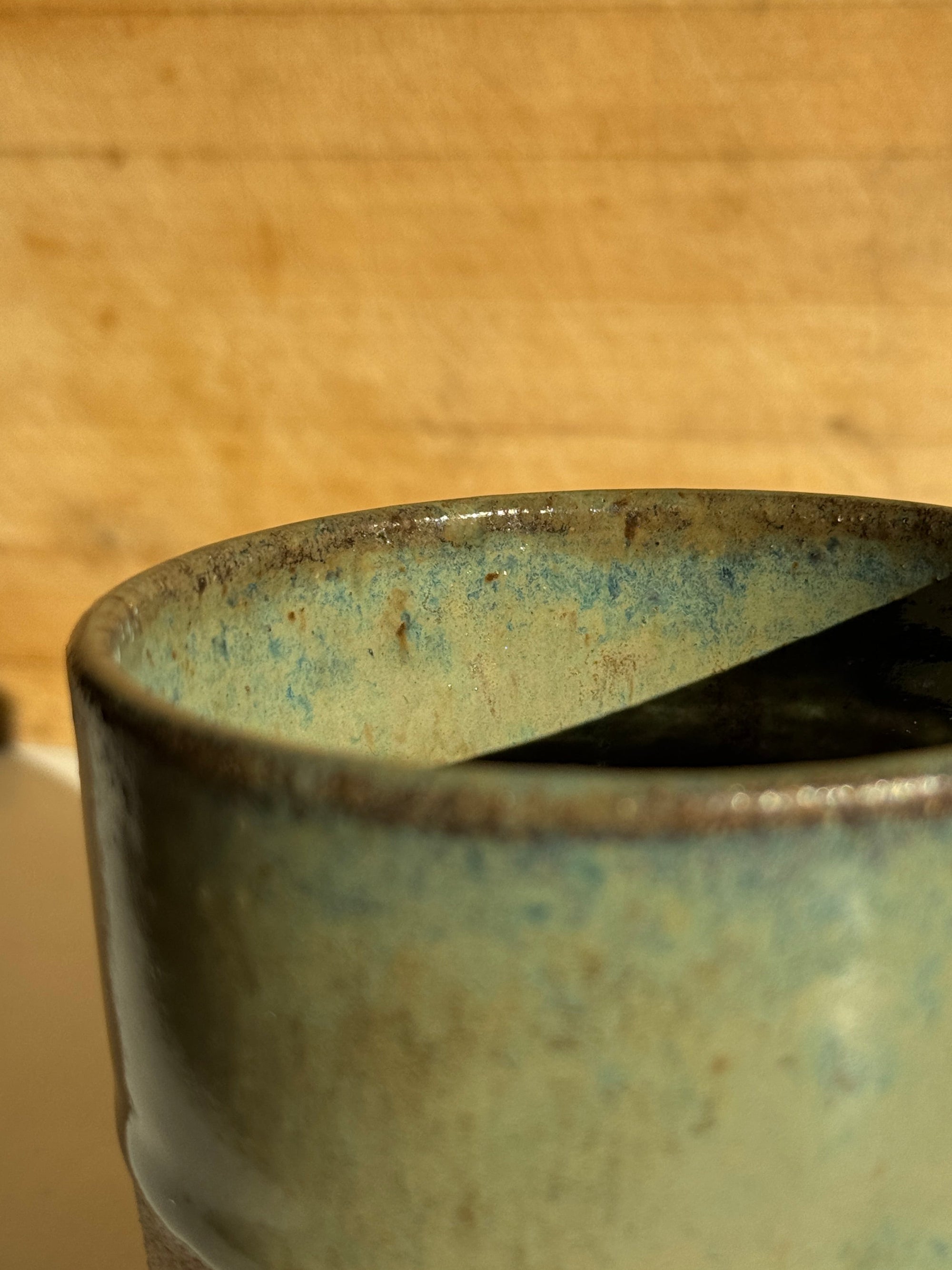 Close-up of a ceramic cup with a textured surface on a wooden background