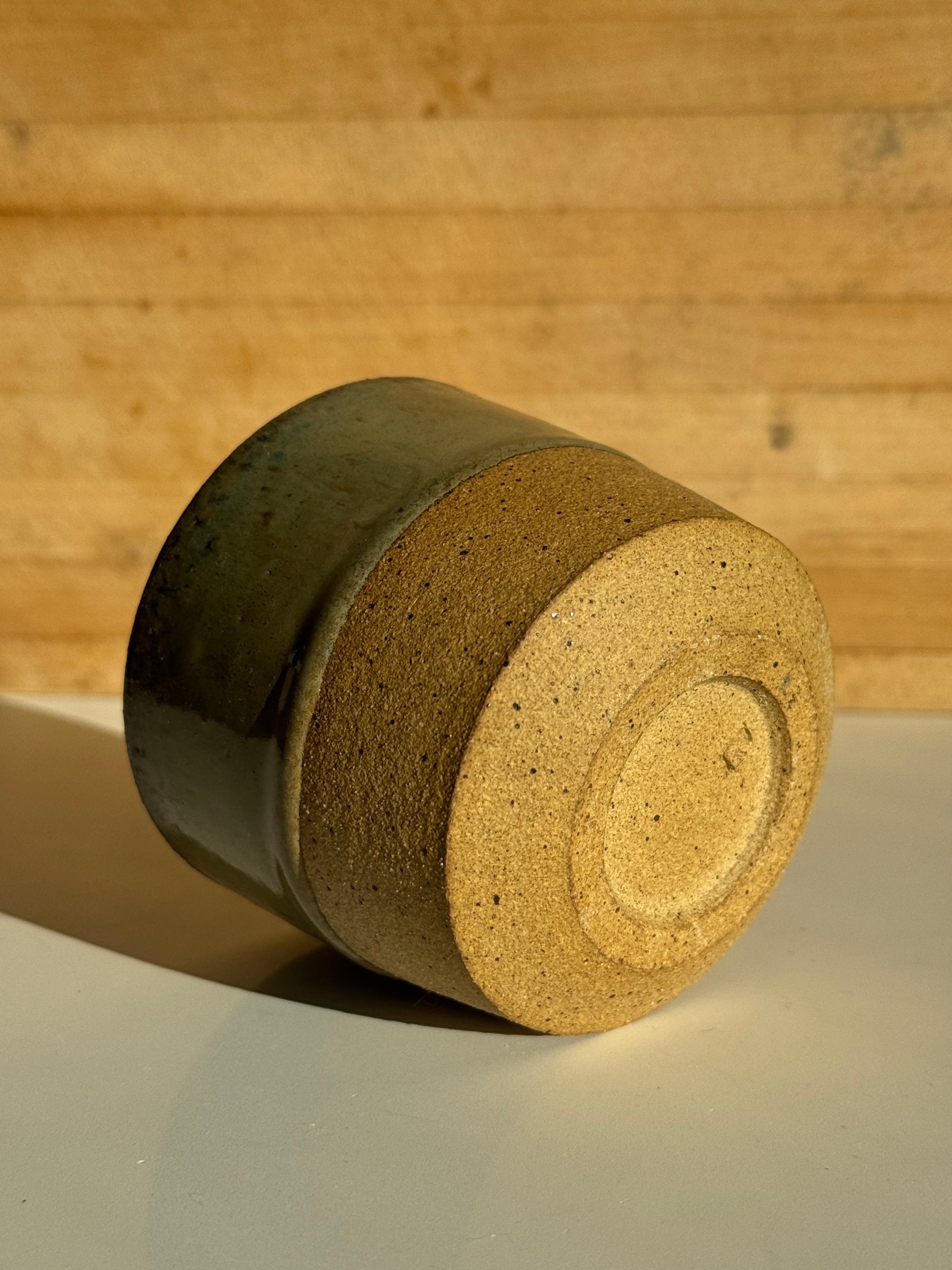 ceramic mug with green denim glaze over light clay.